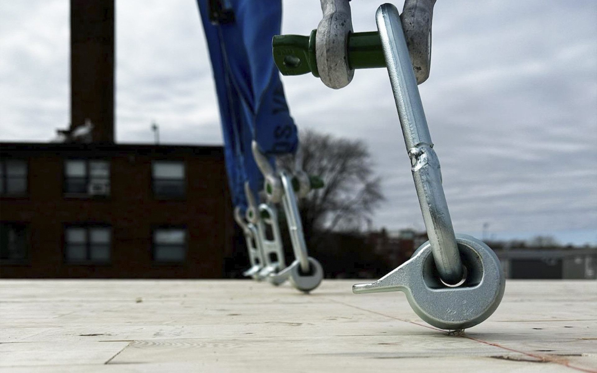 Reusable lifting strap with metal pin anchored to timber panel for on-site handling and lifting of prefabricated wooden elements
