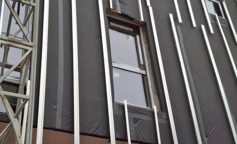 Ventilated façade under construction with breathable membrane and aluminum substructure for building envelope protection 